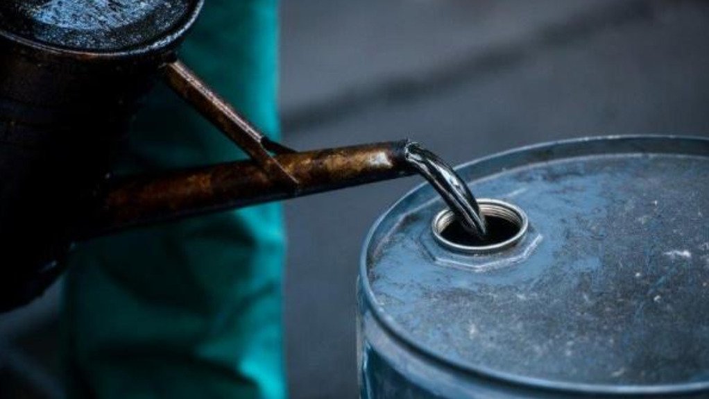 a person pouring used oil into a barrel