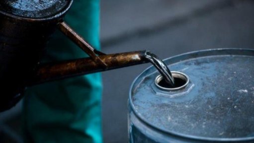 a person pouring used oil into a barrel