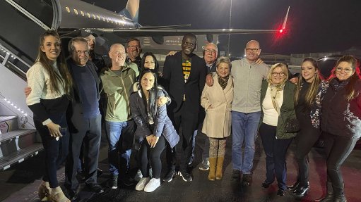 An image showing Minister Ronald Lamola welcoming  home South African engineers Frik Potgieter and Peter Huxham, with their families 