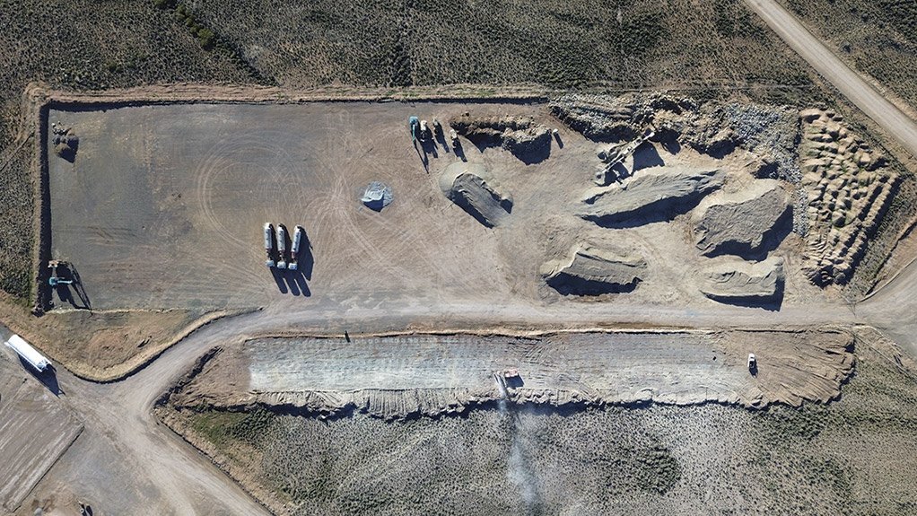 Active crushing operations on the temporary staging area while a drill rig works on extending the platform at the lower end of the site, preparing the area for further construction at Karreebosch Wind Farm