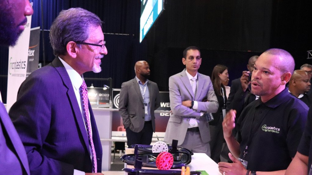 Ministers and dignitaries speaking with a manufacturer at an expo stand at NAACAM