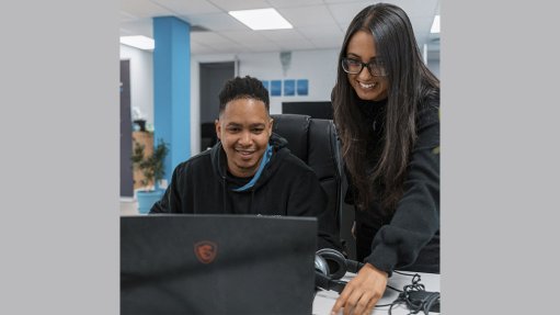 Image of two people looking at a laptop screen