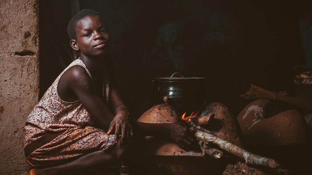 A young girl cooking on coal