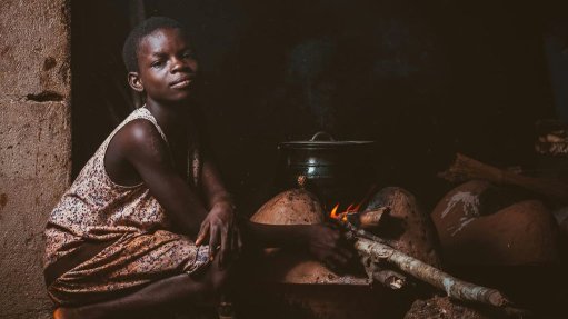 A young girl cooking on coal