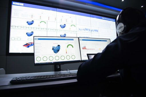 Image of a person in front of multiple digital screens