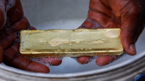 Hands holding a bar of gold