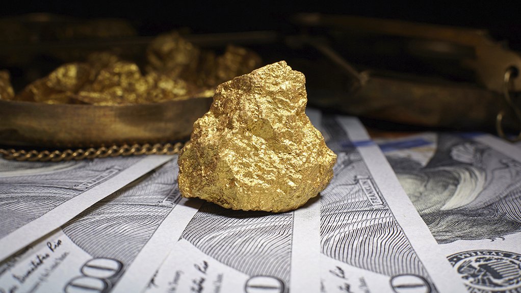 A gold nugget resting on dollar banknotes