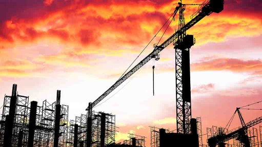 construction site with cranes at sunset