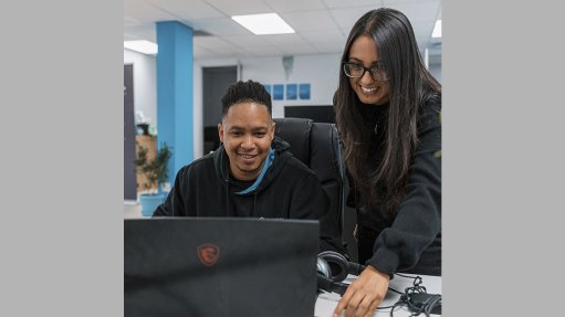 Image of two people looking at a laptop