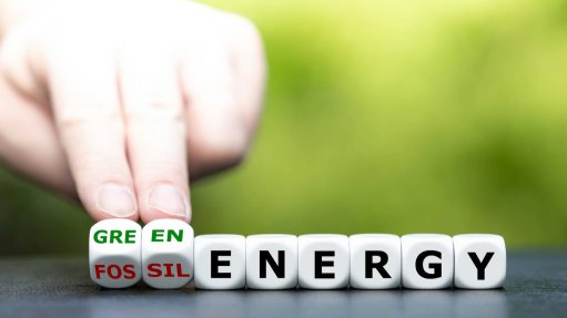 An image depicting a hand changing letters from the words fossil fuel to clean energy