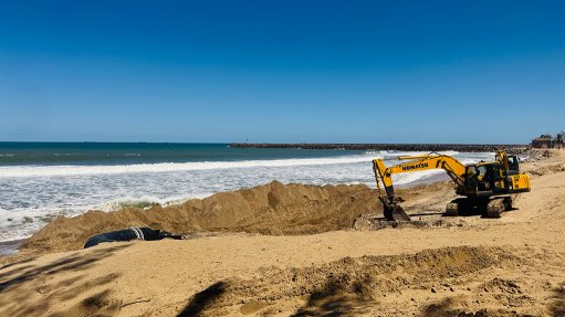An excavator working on Alkanstrand Beach in Richards Bay