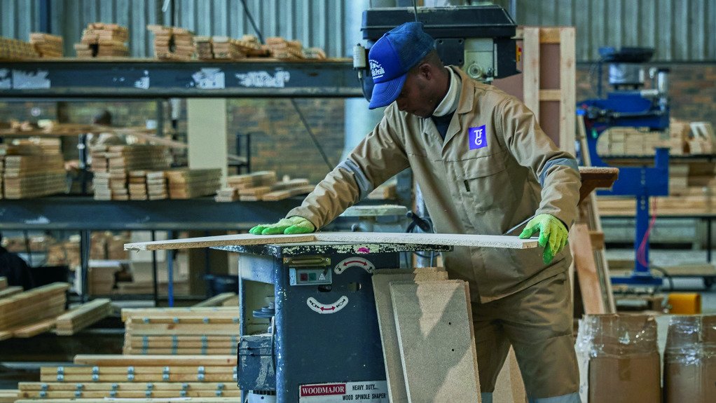 Furniture manufacturing worker working with timber
