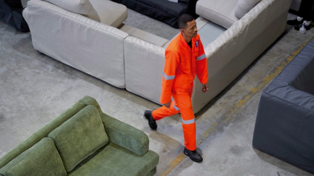 Coricraft furniture warehouse with worker strolling between furniture