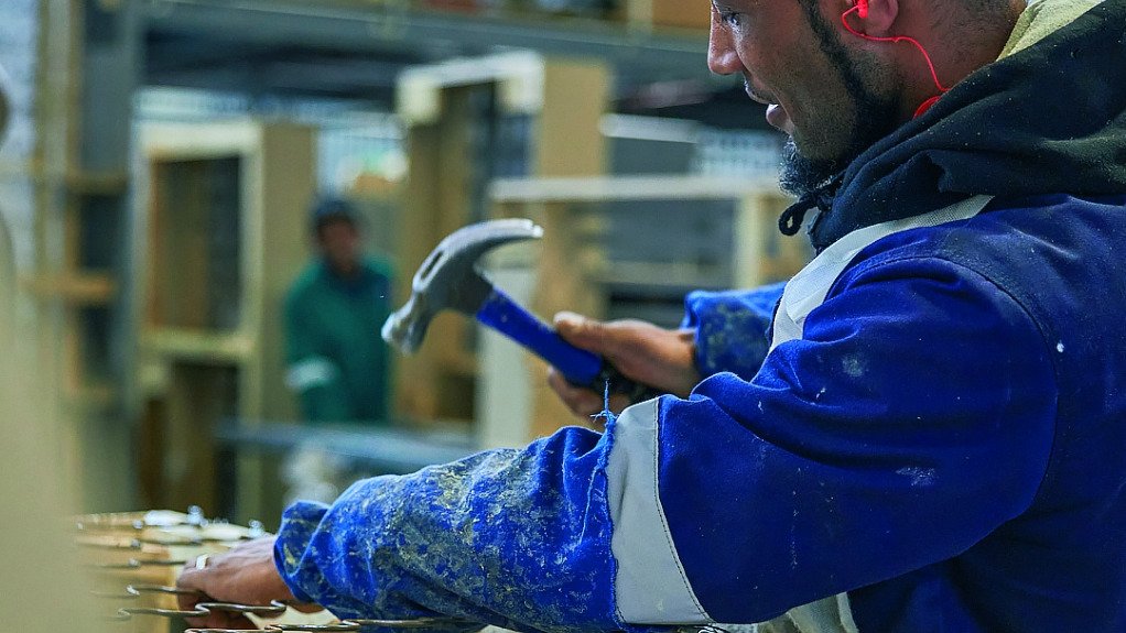 Furniture manufacturing worker working with a hammer