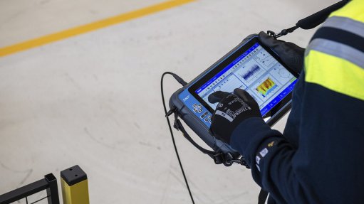 Image of a gloved hand holding a SKF portable vibration analyzer 