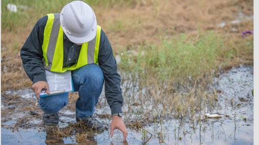 A worker collecting water samples