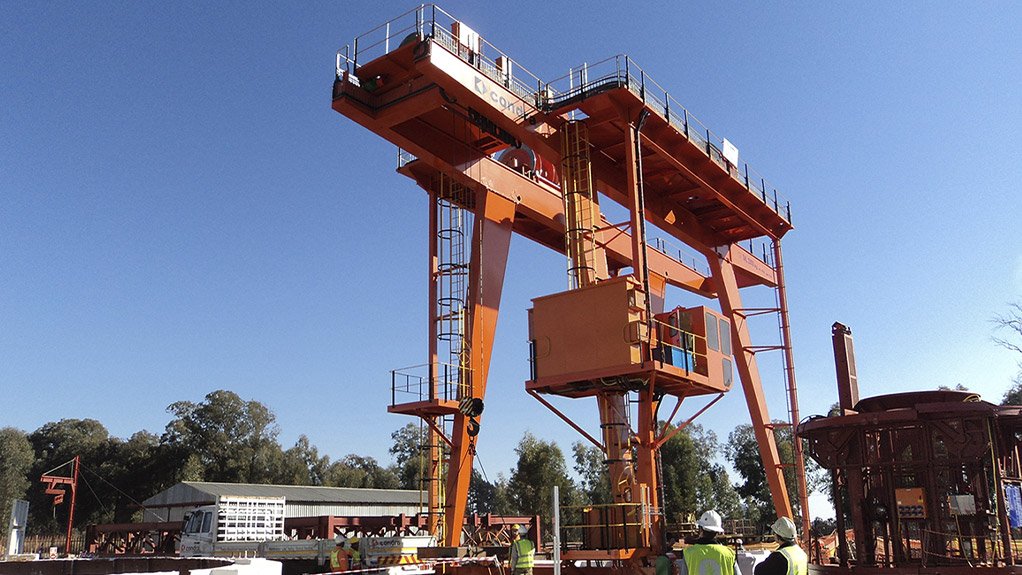 Cementation Africa’s in-house innovation sees a modified  gantry crane used on multiple projects to support pre-sinking activities, hosting the sinking stage and kibble with enhanced flexibility, rapid deployment and automated, human-free tipping systems