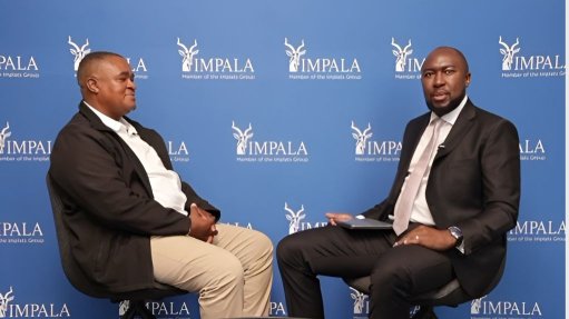 Two people sitting infront of an Impala screen, having a discussion