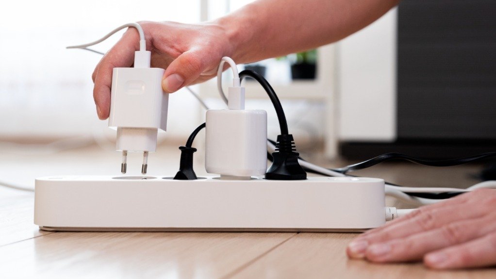 A person plugging in electrical appliances