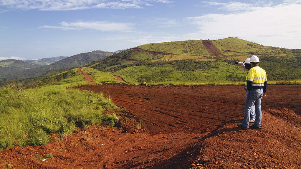 Image of two miners viewing a green fields area