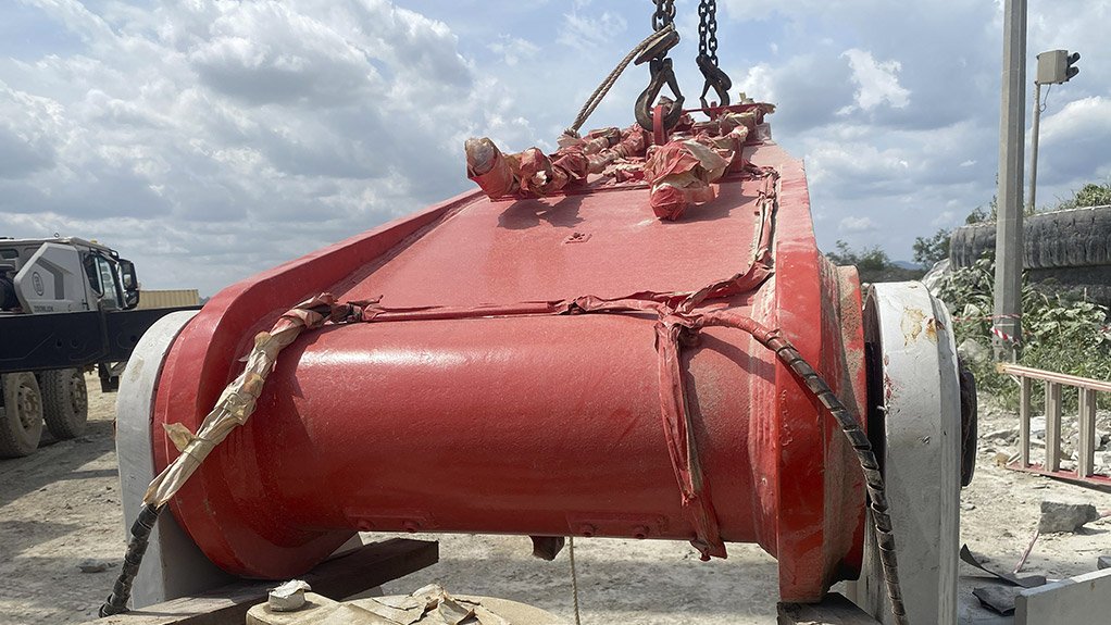 The main boom is being aligned and connected to the pedestal during installation of the Sandvik rock breaker