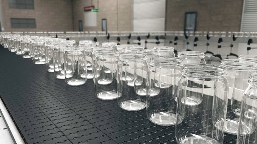 The above image depicts glass containers on a conveyor