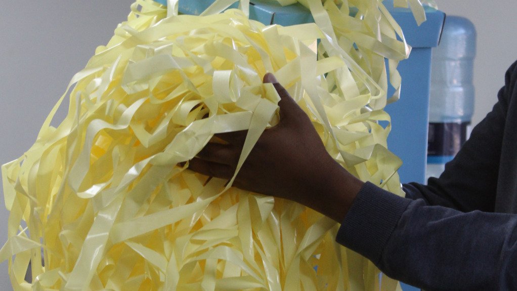 a person holding a load of label-backing paper,