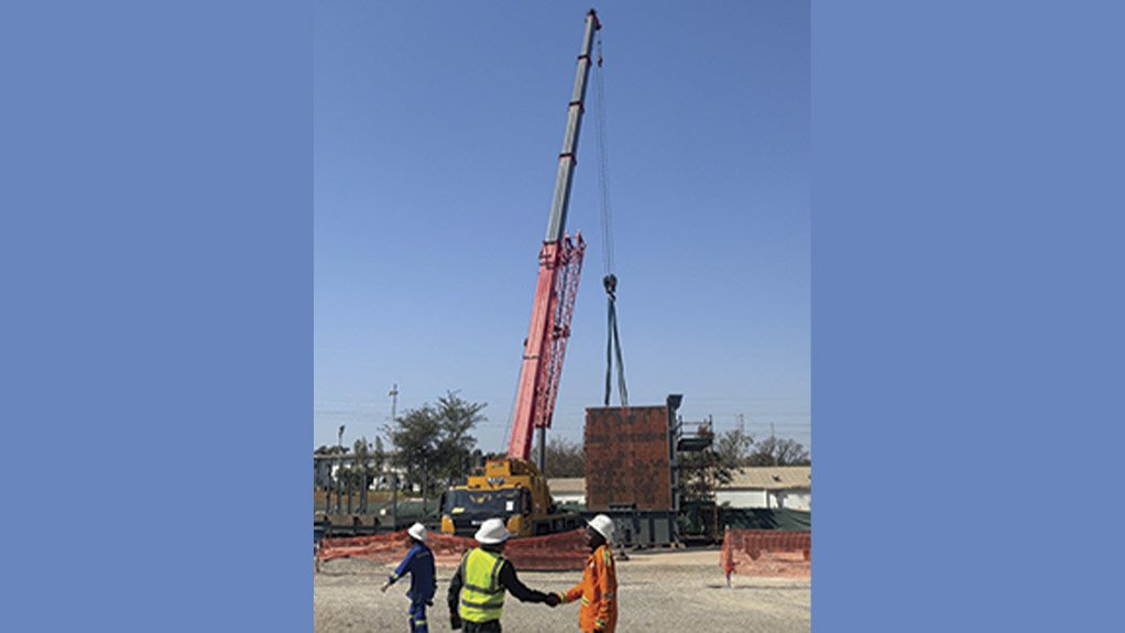 An 80 ton mobile crane lifts a section of the ore loading bin as part of ongoing structural installation activities