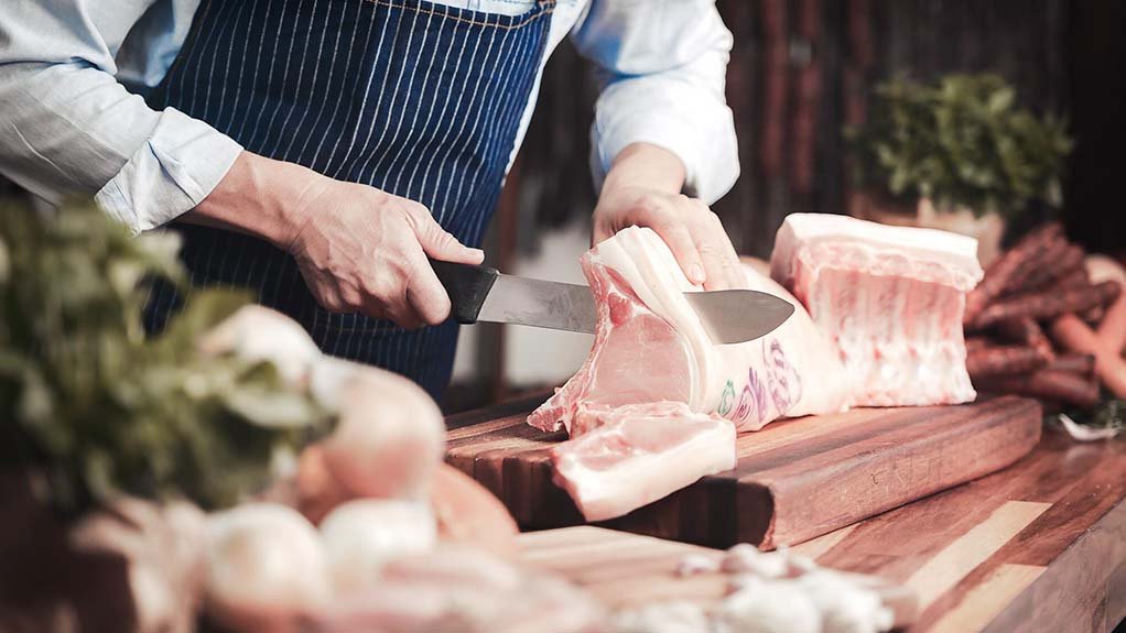 A butcher slicing meat