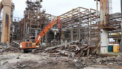 The above image depicts a crane demolishing an old plant