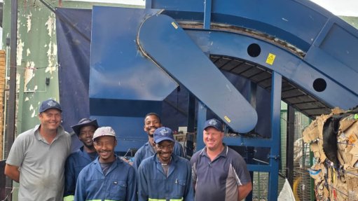 Flink Pik staff posting with a horizontal baler and infeed conveyor system