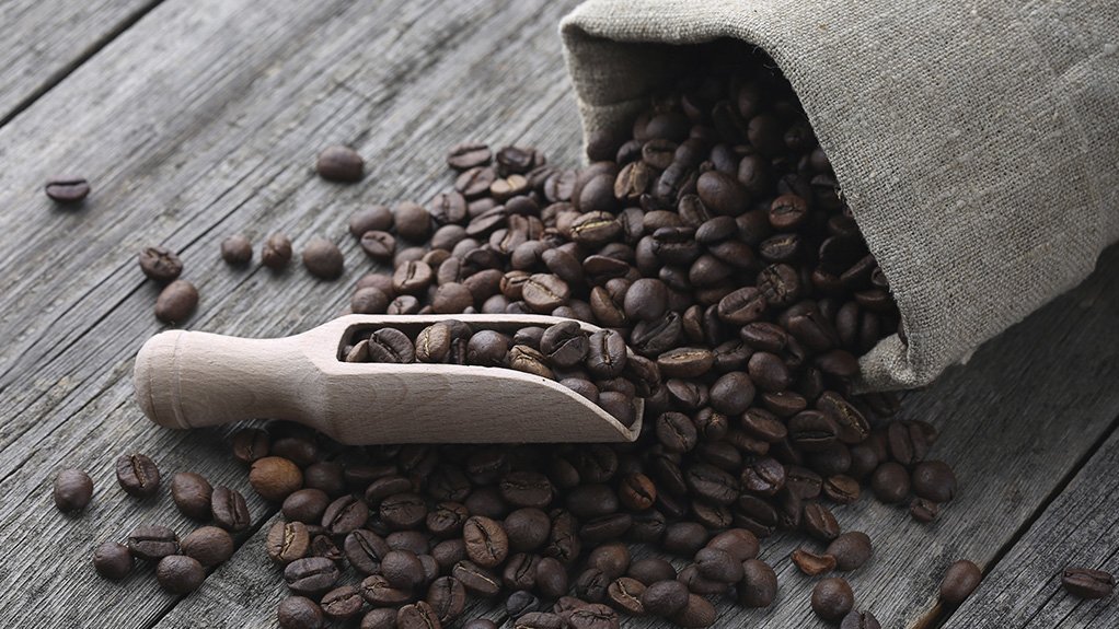 Coffee beans in a burlap sack and spread out on a table