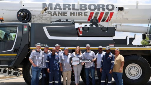 The above image depicts a Marlboro Crane Hire crane with the companies employees in front of it