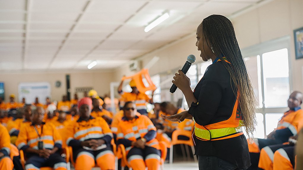 An employee wearing PPE discusses teamwork and safety measures with colleagues at the Jwaneng mine in Botswana