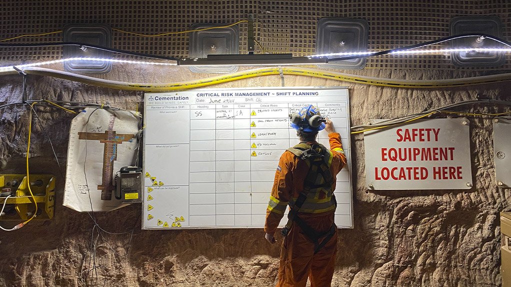 Un membre d’une équipe souterraine finit la planification de son quart de travail et l’évaluation des risques critiques sur un chantier de Cementation