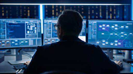 The above image depicts an IT technician in front of a series of computers