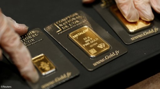 Hands holding gold bars