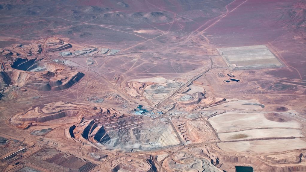 The above image depicts an aerial view of an open-pit copper mine in Atacama Desert, Chile