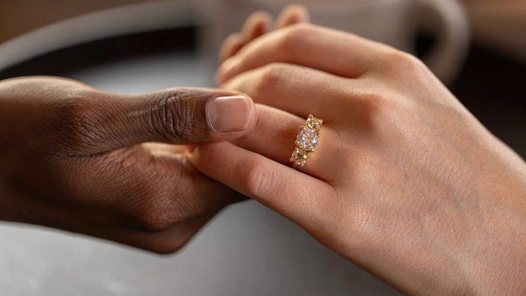 People holding hands, with a diamond ring on the woman's hand