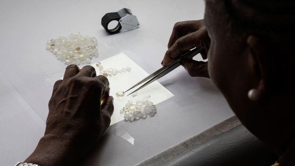 An employee carefully sorts rough diamonds at the GSS facility in Gaborone, Botswana