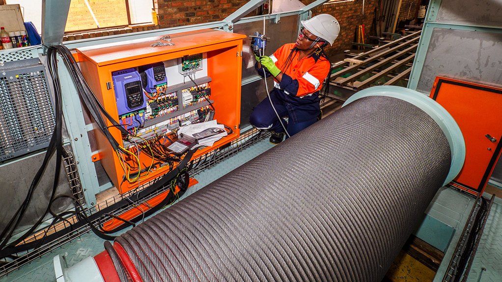 Image of a tachnician doing work on the control panel of a Condra hoist.