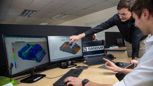 Image of two people looking at images on a computer monitor