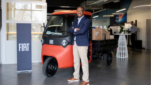 Kabelo stands infront of the new Fiat Trisc, a three-wheeler electric delivery vehicle