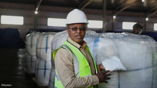 Zimbabwean Minister of Mines and Mining Development Polite Kambamura shows lithium sulphate during a site visit at Prospect Lithium Zimbabwe, a lithium mine operated by a subsidiary of Chinese company Zhejiang Huayou Cobalt, in Goromonzi district, east of Harare