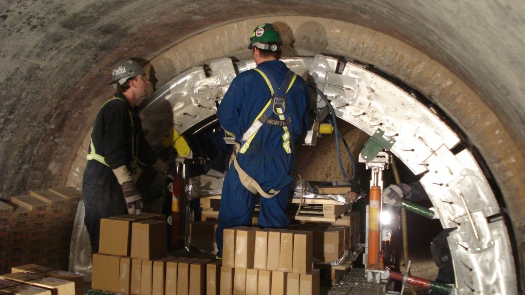 An image of masons using the bricking machine to repair a kiln