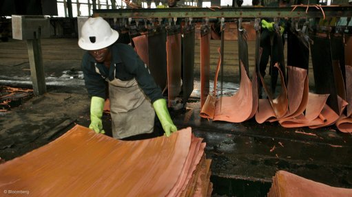 A worker stacks copper plates