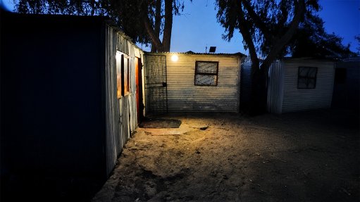 A wall-mounted, solar-powered light in Witsand at night