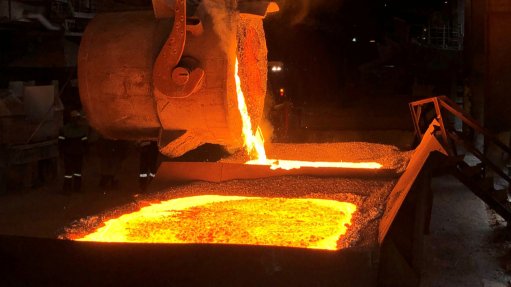 a smelter pouring hot alloy into a vat