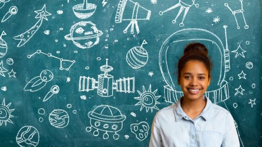 Child standing in front of a school blackboard