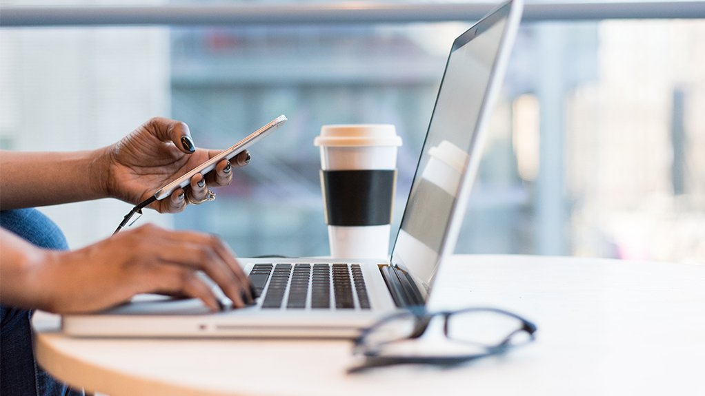 Person using a laptop and cellphone